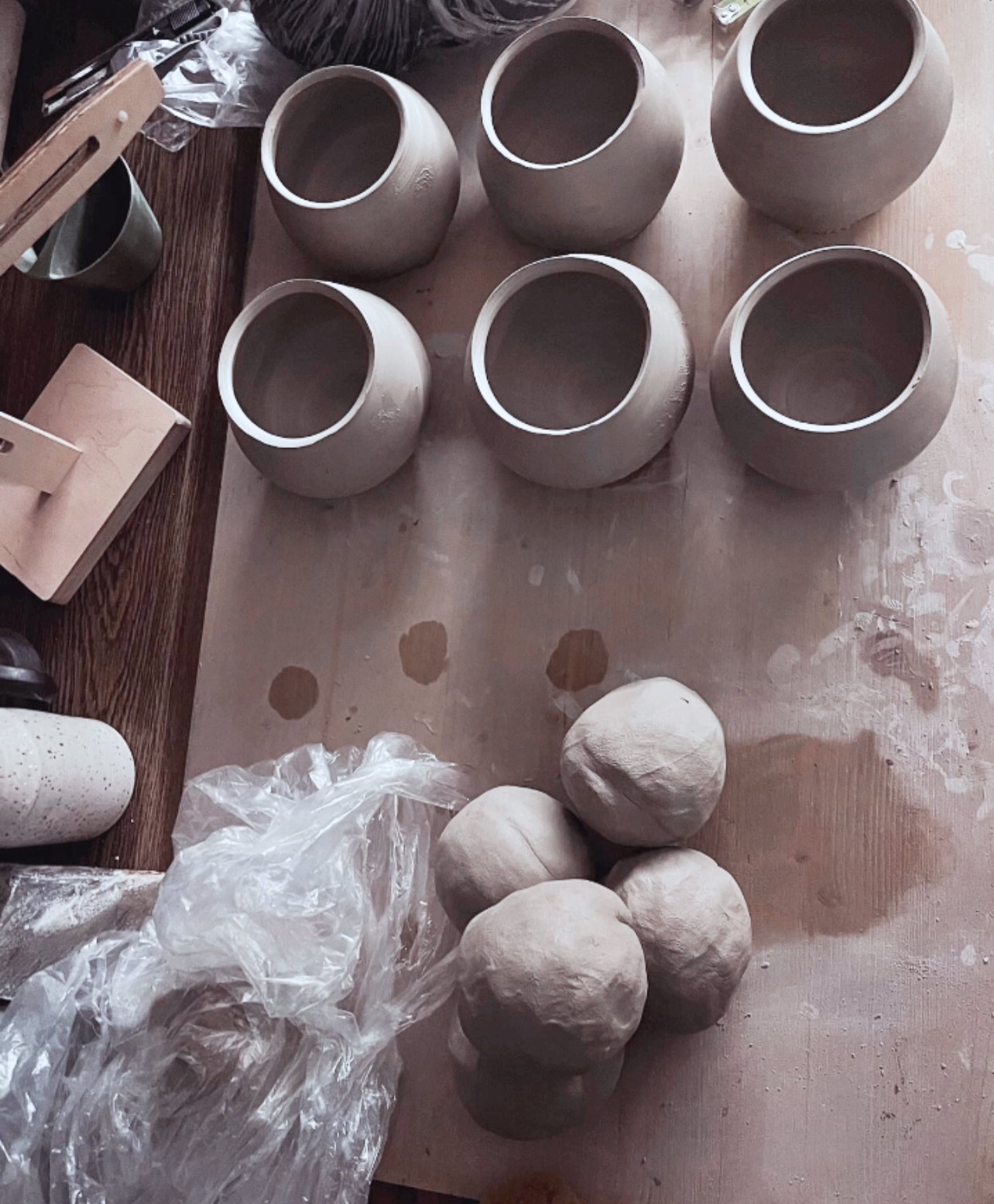 Becher und vorbereitete Tonkugeln auf dem Werktisch